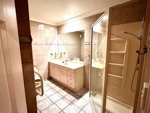 een kleine badkamer met een wastafel en een douche bij West Harbour White House (西港白宫） in Auckland