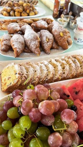 a table with plates of different types of pastries and fruit at Hotel LIDI in Sarandë