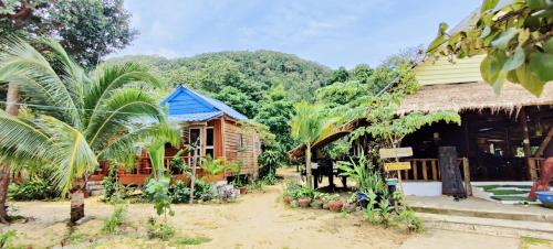 a house with a blue roof and some trees at Mangrove Beach Bungalows in Koh Rong Sanloem