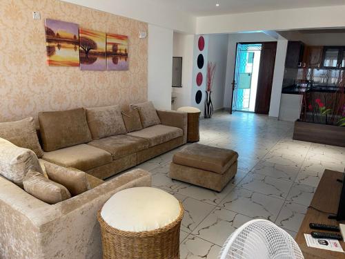 ein Wohnzimmer mit einem Sofa und einem Tisch in der Unterkunft Pinebreeze Holiday Resort in Nyali