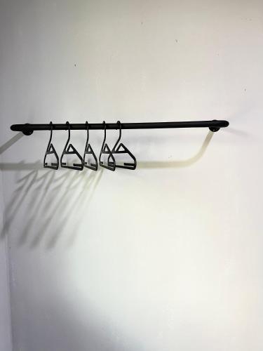 a black rack with four glasses on a white wall at Modern Style Village House in Kuching