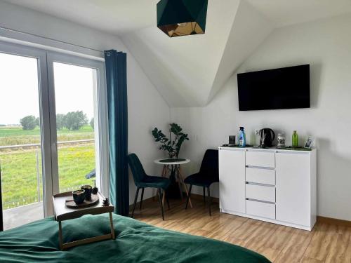 a bedroom with a bed and a television and a table at Bałtyckie Klimaty in Stegna