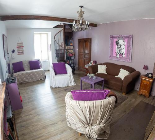 a living room with purple and white furniture at La p'tite maison in Blacy