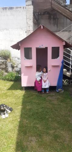two children sitting in a pink play house at Casa Apartamento Campestre en las Faldas del Tayta Imbabura in San Juan de Ilumán