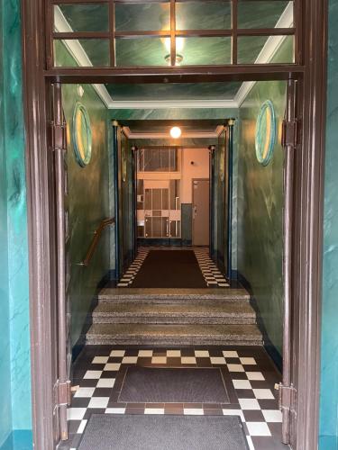 a hallway leading to a room with a checkered floor at Rautatienkatu 13 B in Lahti