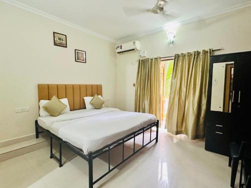 a bedroom with a bed and a large window at Hotel Leela Inn Candolim in Marmagao