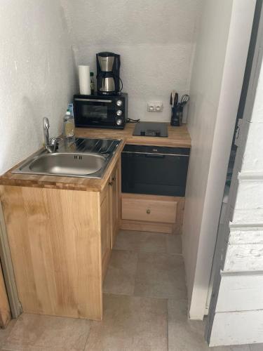une petite cuisine avec un évier et un micro-ondes dans l'établissement sejour romantique entre mer et ciel, à Porri