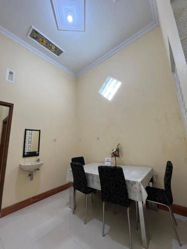 comedor con mesa blanca y sillas en Guesthouse Eldys, en Gondowulung