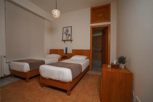 a bedroom with two beds and a dresser in it at Domaine de Chouchene in Şaḩrat al Qashsh
