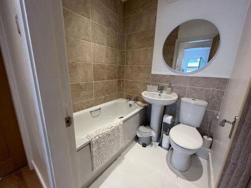 a bathroom with a sink and a toilet and a bath tub at Something a little bit special! in Llandudno