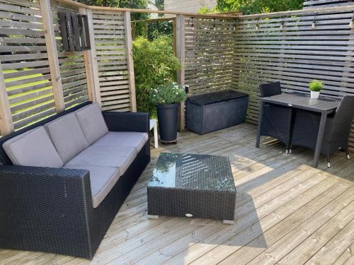 a patio with a couch and a table on a deck at Studio 51 Örgryte in Gothenburg