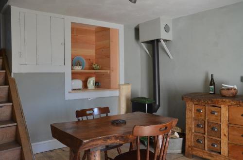 une salle à manger avec une table et des chaises en bois dans l'établissement les gites du passage: le nid, à Passenans