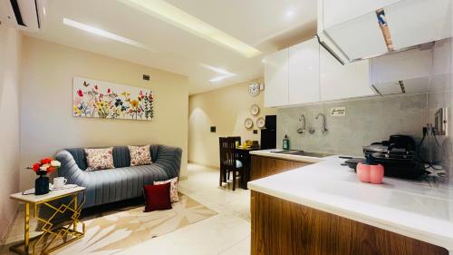 a kitchen and a living room with a couch at ZEN Suites Gurgaon - LUXE Stays Collection in Gurgaon