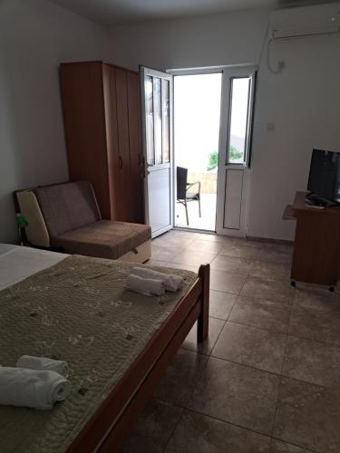 1 dormitorio con cama, sofá y TV en Apartments Dragišić, en Sveti Stefan