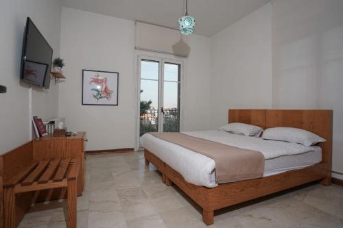 a bedroom with a large bed and a television at Domaine de Chouchene in Şaḩrat al Qashsh