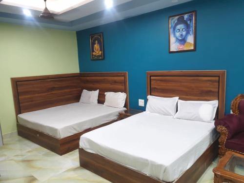 two beds in a room with blue walls at Tapovan Resort in Rishīkesh