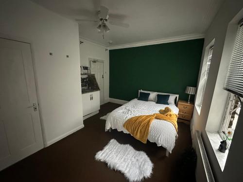 a bedroom with a bed and a green wall at The Griffen Lodge in Plumstead