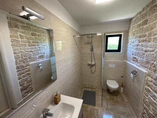 a bathroom with a shower and a sink and a toilet at Božini dvori in Drniš