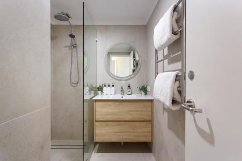 een badkamer met een douche, een wastafel en een spiegel bij Eliza's Lookout in Perth