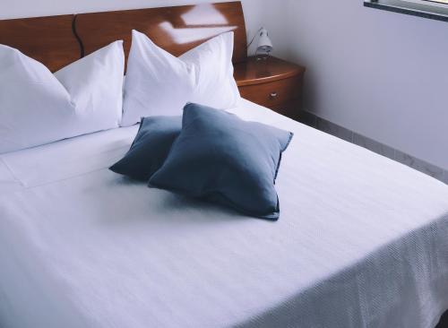 two pillows sitting on top of a white bed at Estrela do Geres in Geres