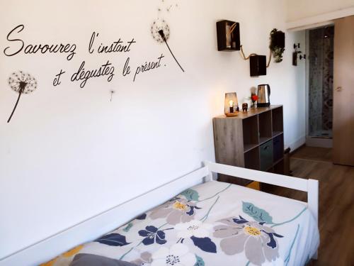 une chambre avec un lit avec un panneau sur le mur dans l'établissement La campagne à la ville..., à Beauvais