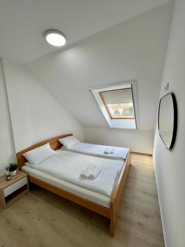 a small bedroom with a bed with a window at C rooms by Cortado in Zrenjanin