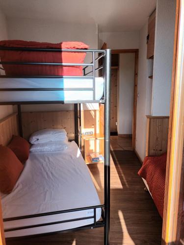a dorm room with two bunk beds and a hallway at PLAGNE-SOLEIL Pied des pistes in La Plagne Tarentaise