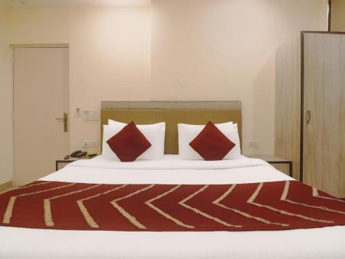 1 dormitorio con 1 cama con almohadas rojas en Hotel Grace, Karol Bagh, New Delhi en Nueva Delhi