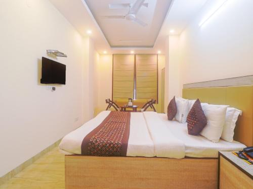 a bedroom with a large bed with a tv on the wall at Hotel Grace, Karol Bagh, New Delhi in New Delhi