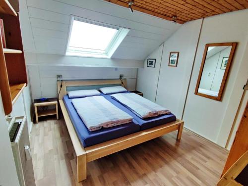 a bed in a small room with a window at Ferienwohnung Jepsen in Glücksburg