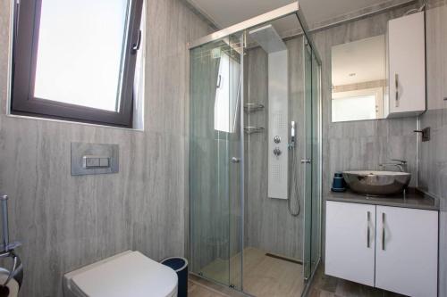 a bathroom with a shower and a toilet and a sink at Deniz gören lüks yeni eşyalı ferah 4+1 özel villa in Kas