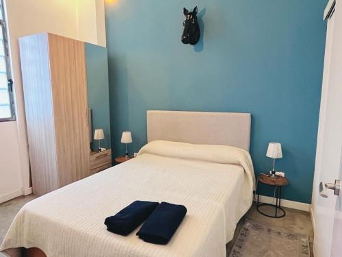 - une chambre avec un lit blanc et deux murs bleus dans l'établissement Moderno apartamento 2habitaciones Avda América, à Madrid