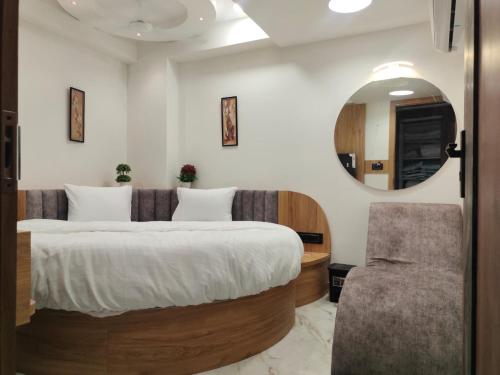 um quarto com uma cama grande e um espelho em HOTEL LAVISH em Ahmedabad
