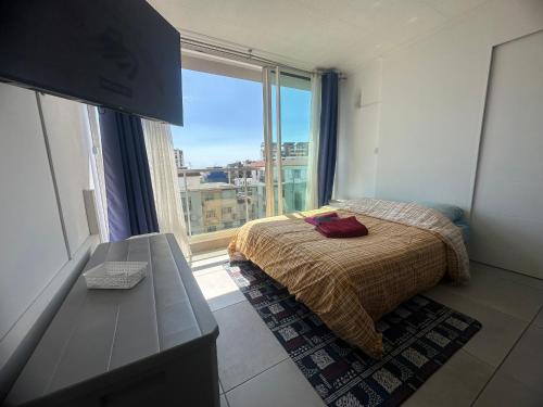 a bedroom with a bed and a large window at Appartement T2 Colombier pour 5 personnes vue mer in Sainte-Clotilde
