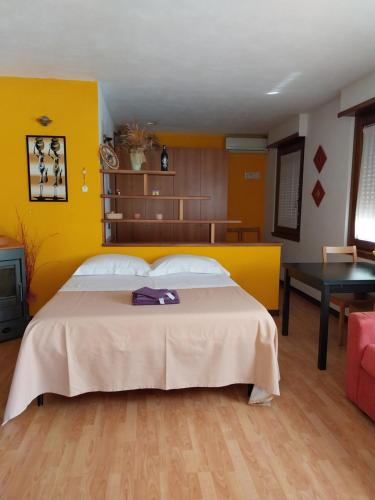 una camera da letto con un grande letto con una parete gialla di Tirano in relax a Tirano