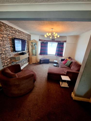 Comfortable Single Room في Welling: غرفة معيشة مع أريكة وجدار حجري