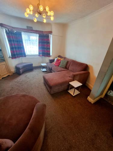 a living room with a couch and a table at Comfortable Single Room in Welling