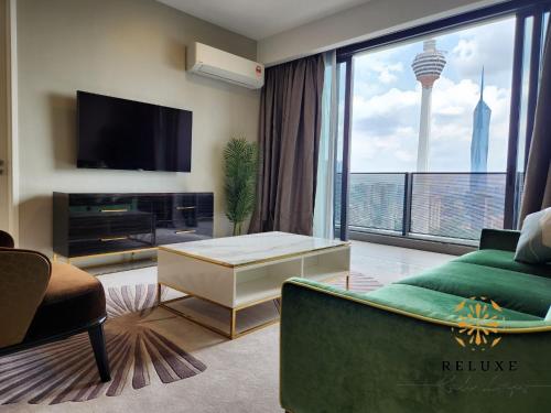 a living room with a couch and a tv at The Platinum 2 KLCC Premium Suite by Reluxe Kuala Lumpur in Kuala Lumpur