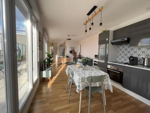 une cuisine avec une table recouverte d'une nappe dans l'établissement Appartement Cosy Champs sur Marne, à Champs-sur-Marne