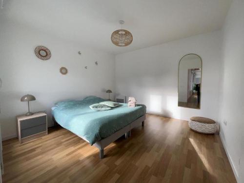 une chambre avec un lit et un miroir au mur dans l'établissement Appartement Cosy Champs sur Marne, à Champs-sur-Marne