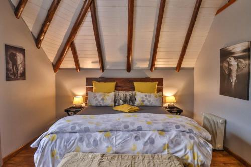 a bedroom with a large bed and two lamps at CASTLE COTTAGE Self catering fully equipped homely 120sqm double story king bed cottage in a lush green neighborhood in Hillcrest