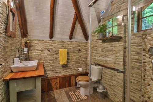 y baño con aseo, lavabo y ducha. en CASTLE COTTAGE Self catering fully equipped homely 120sqm double story king bed cottage in a lush green neighborhood, en Hillcrest