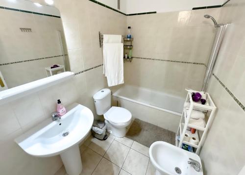 W łazience znajduje się umywalka, toaleta i prysznic. w obiekcie los Gigantes Jardines del Mar w mieście Puerto de Santiago