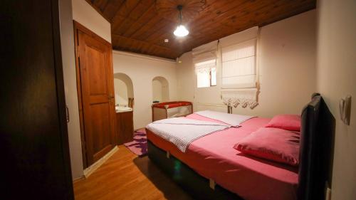 um quarto com uma cama com um edredão vermelho em Dibekönü Konak em Safranbolu