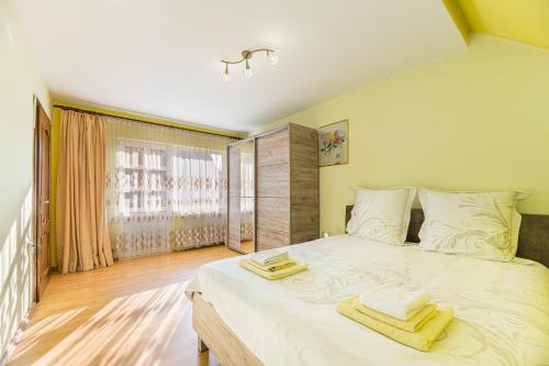 a bedroom with a large bed with towels on it at Casa David in Săcele
