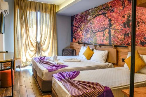 a hotel room with two beds and a painting on the wall at Lupo Libero Hotel Spa in Antalya