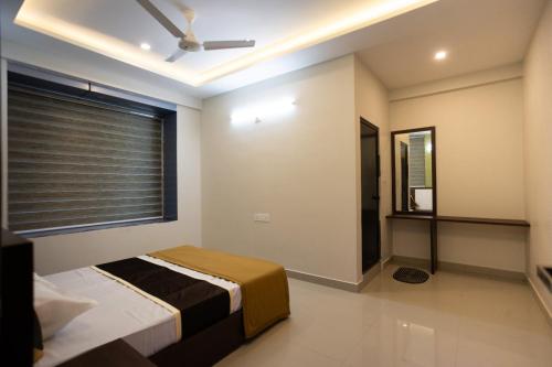 a bedroom with a bed and a ceiling fan at The Green Room Residency in Padinjarathara
