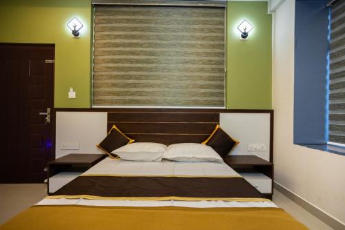 a bedroom with a bed with two pillows and a window at The Green Room Residency in Padinjarathara
