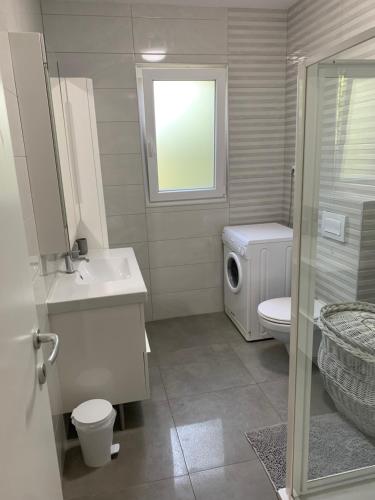 baño con lavabo y aseo y ventana en HOUSE IVY en Murter