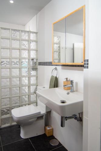 a bathroom with a white sink and a toilet at Serendipia del Sur in Candelaria